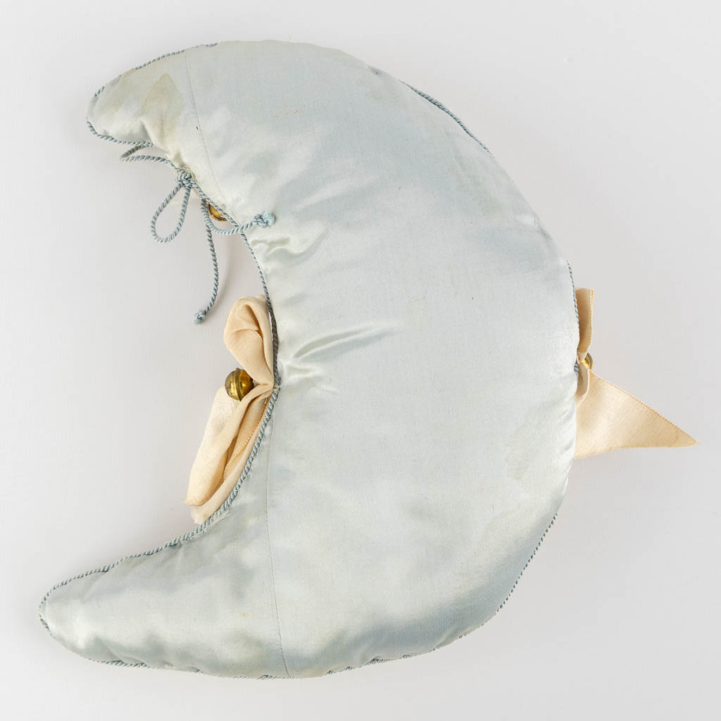 An antique doll in a crescent moon-shaped sleeping bag. Putnam 1922. (W:23 x H:26 cm)