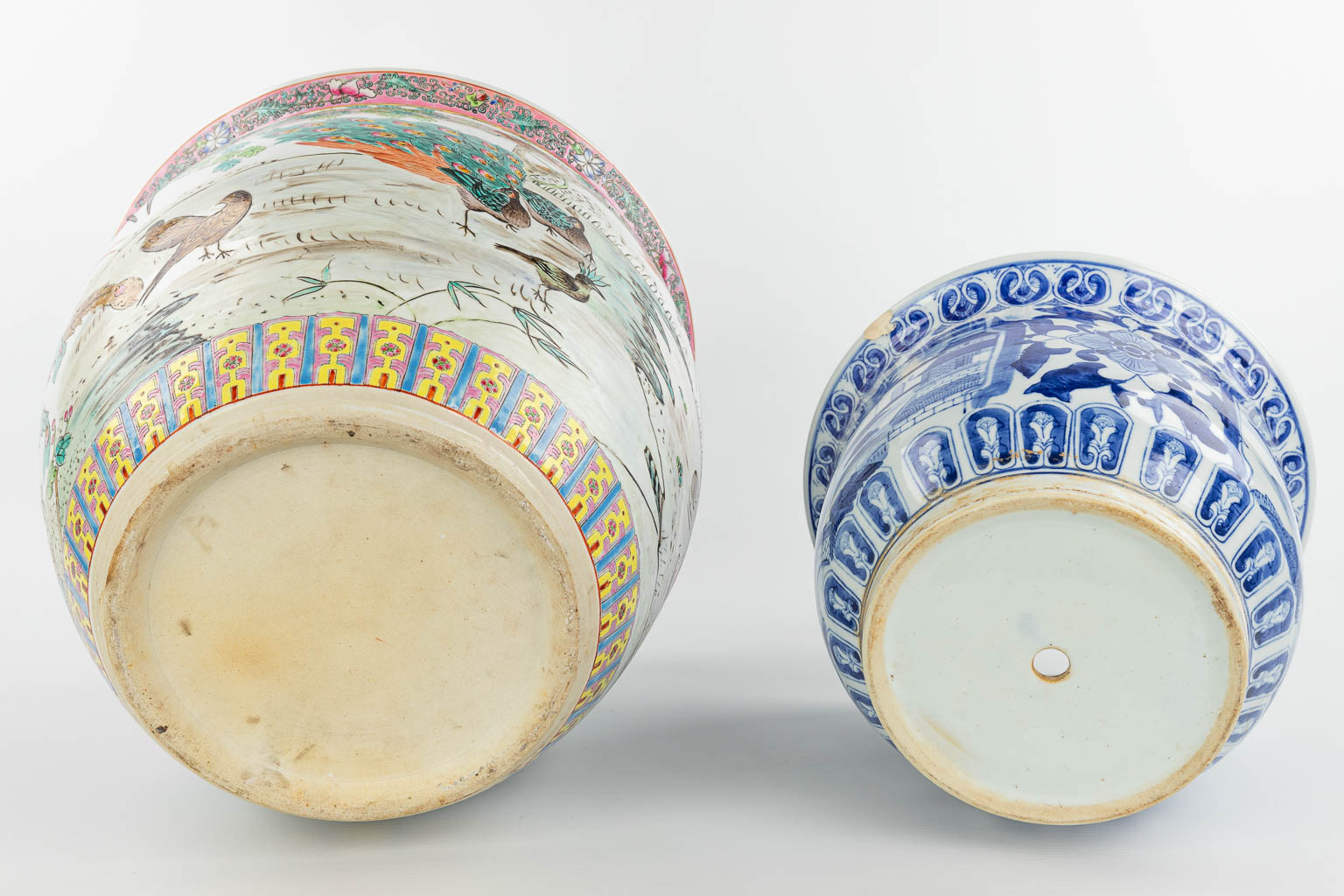 Een collectie van 2 Chinese cache-pots gemaakt uit porselein waarvan 1 met blauw-wit en ander met pauwendecor (H:35cm)