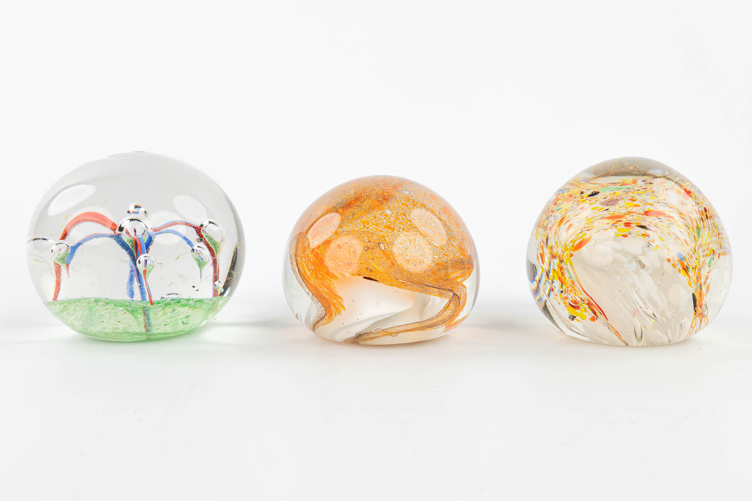A collection of 7 paperweights made in Murano and decorated with abstract glass art. (H:7,5cm)