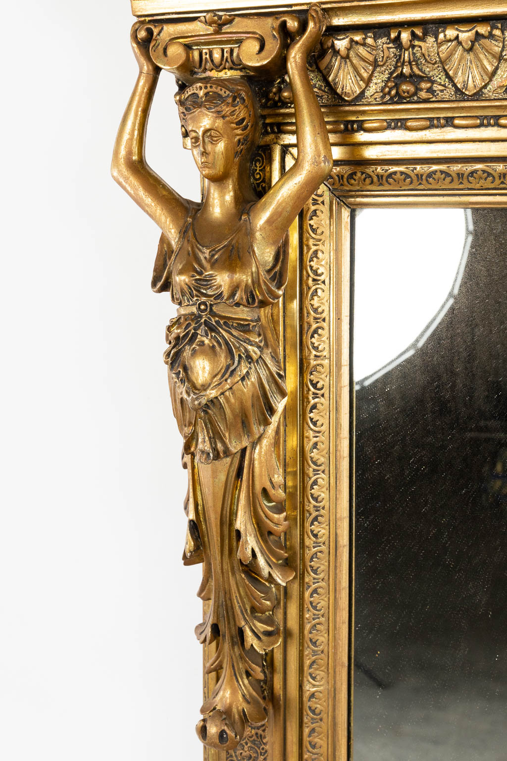 Een grote spiegel, verguld en afgewerkt met Karyatides. Circa 1900. (W:123 x H:220 cm)