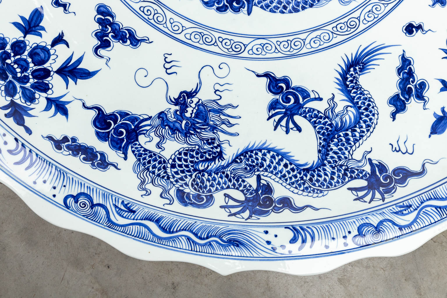 Een groot Chinees sierbord versierd met blauw-wit decor van draken. 20ste eeuw. 