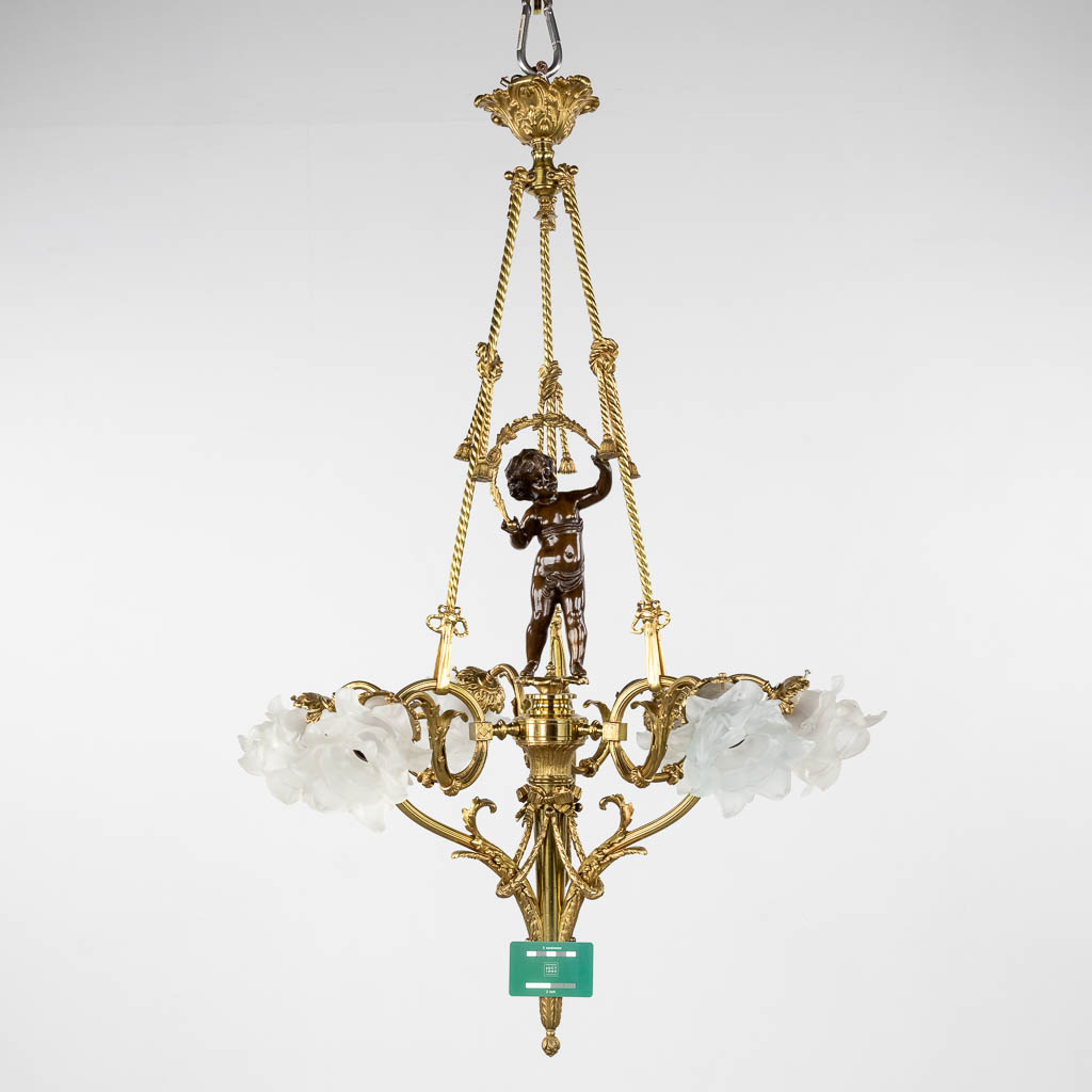 A ceiling lamp, gilt and patinated bronze, decorated with a putto and rose glass shades. 20th C. (H:100 x D:66 cm)