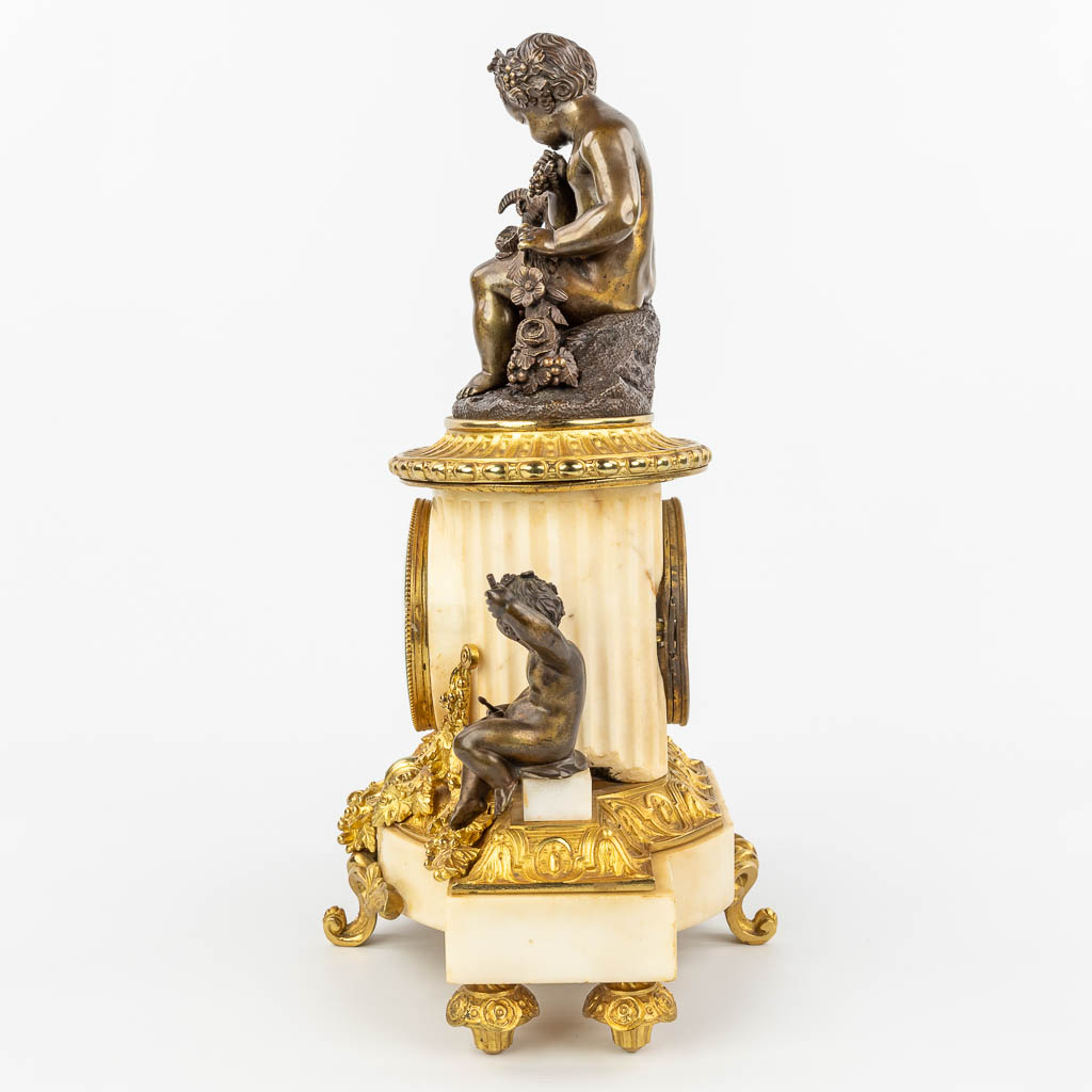 Een klok gemaakt uit marmer en versierd met verguld en gepatineerd brons in Lodewijk XVI stijl. (H:42cm)