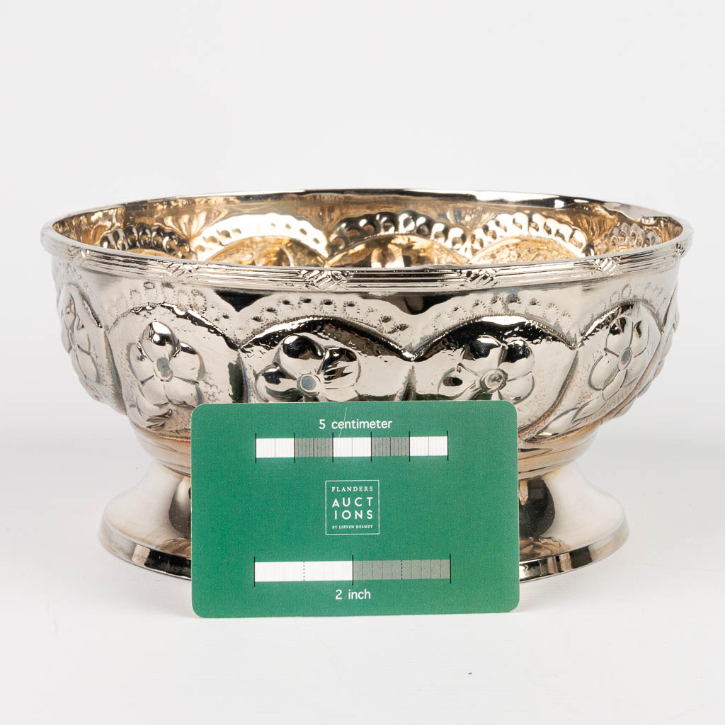 A silver-plated bowl decorated with repousse flowerdecor. 