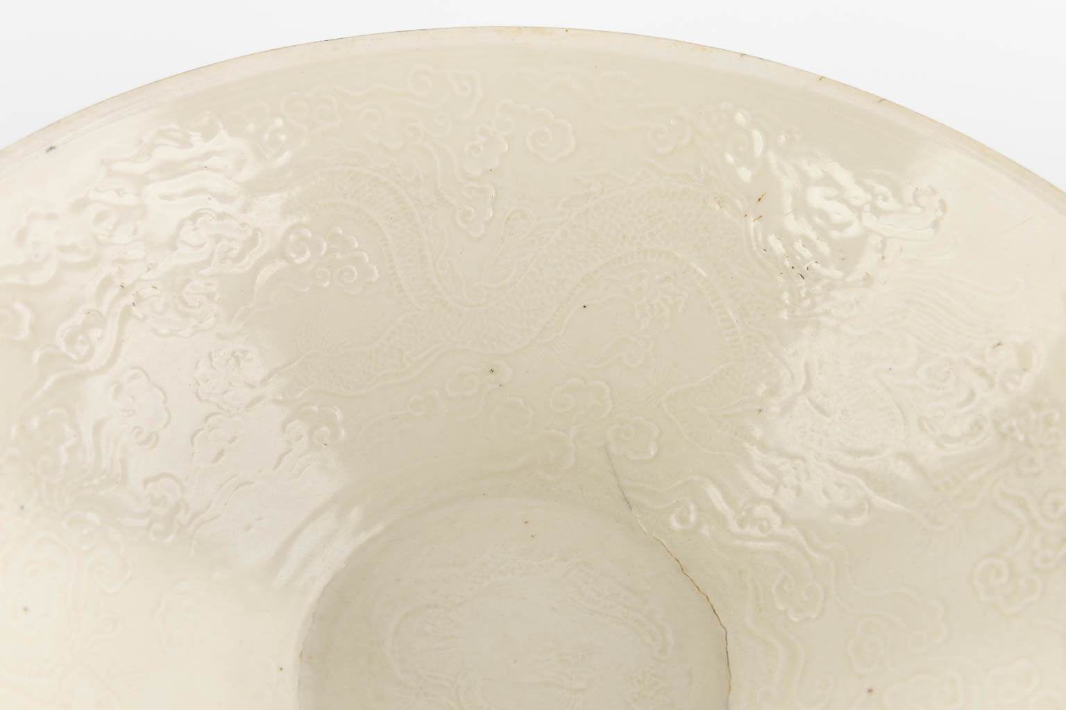 A Chinese bowl with monochrome glaze 'Dingyao', Southern Song style, decorated with dragons. (L:28,2 x W:27,3 x H:10 c