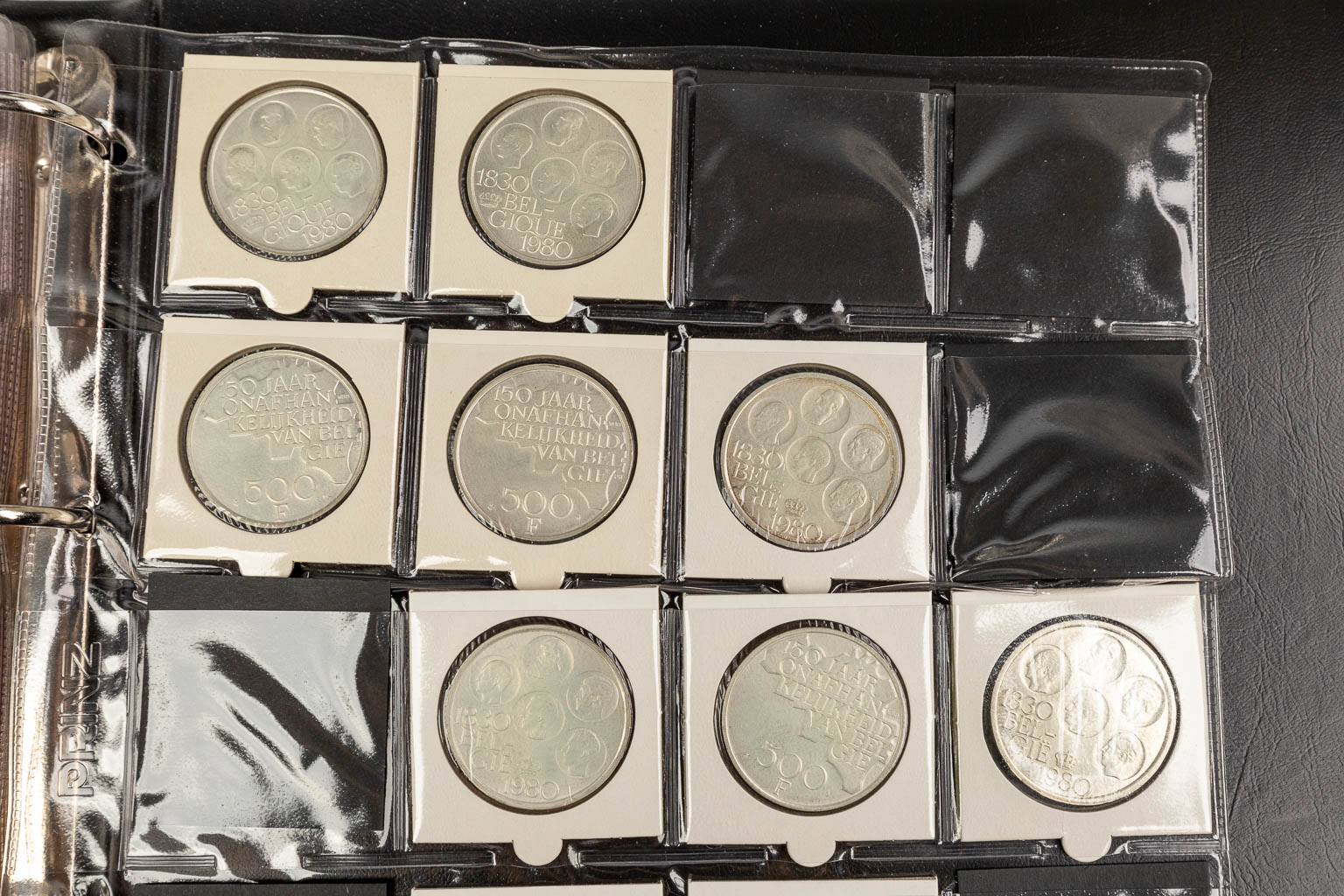 A large collection of coins, of which most are silver and 2 are gold. 