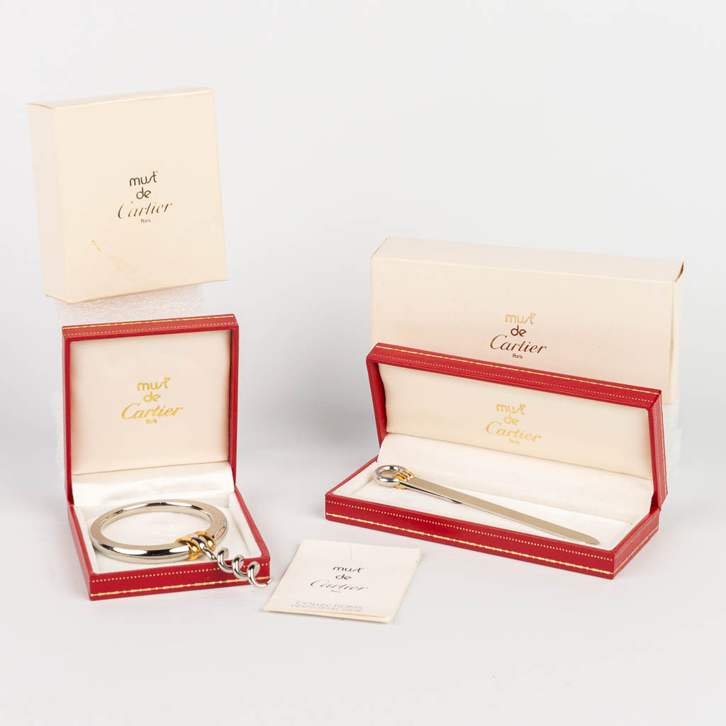 Een set 'Must De Cartier' accessoires. Een kurkentrekker en bladwijzer uit de 'Collection Personal Line.' 