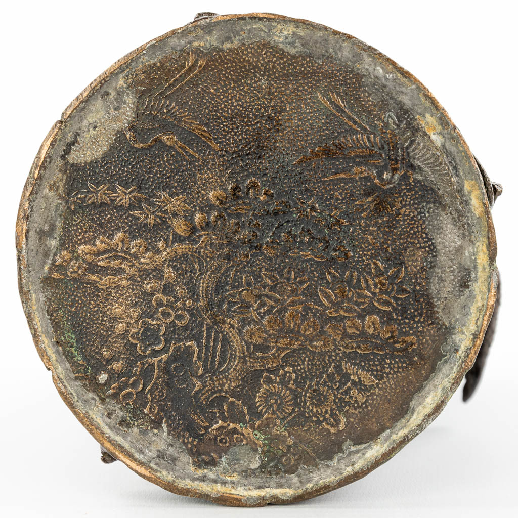 Een borstelpot gemaakt uit brons en versierd met Mythologsiche figuren, kraanvogels en een bonsai boom. (H:25cm)