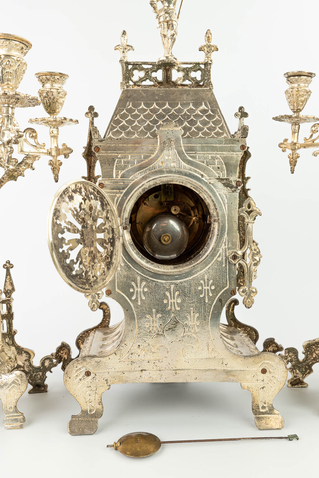 Een driedelige schouwgarnituur gemaakt uit verzilverd brons in neogotische stijl. (H:62cm)