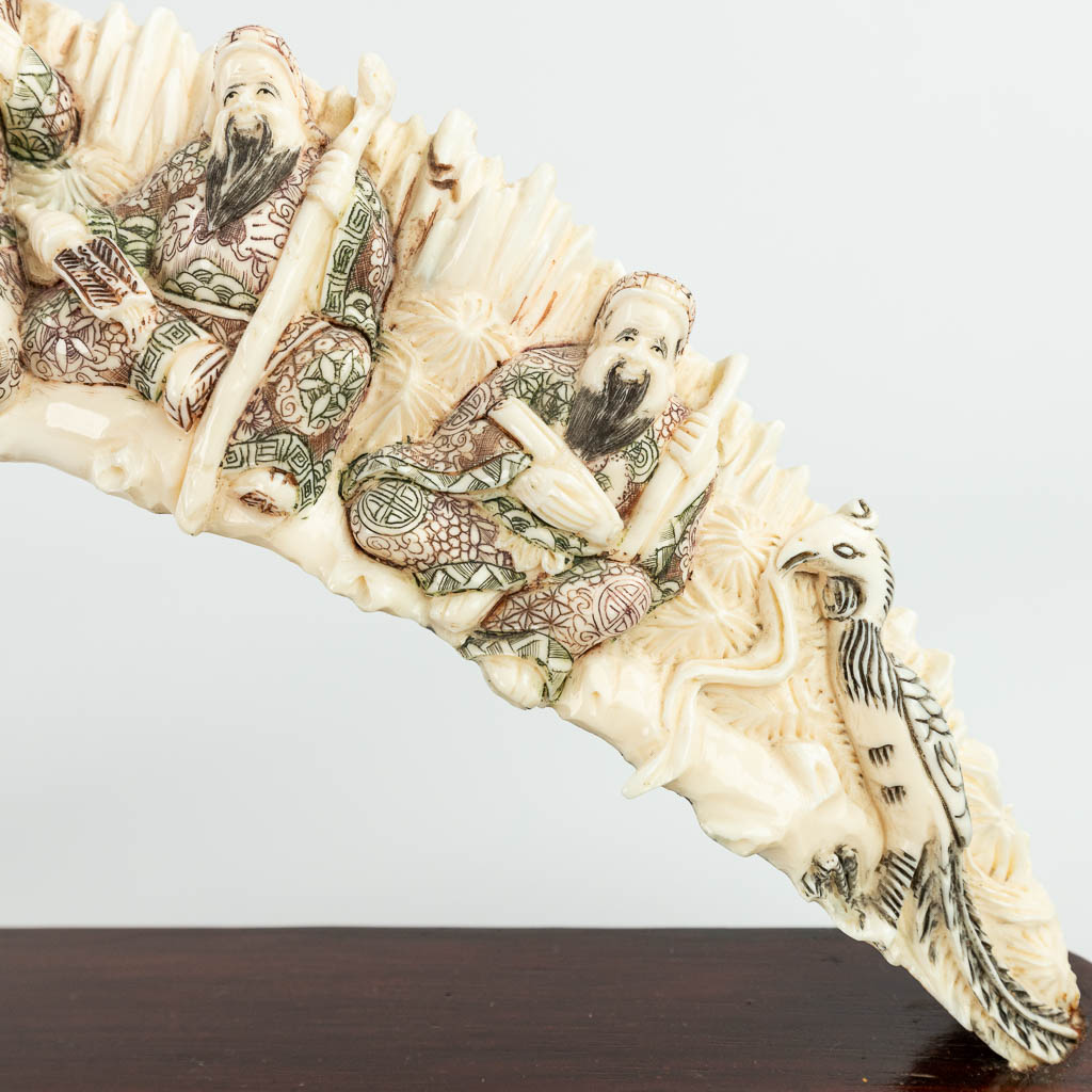A collection of 2 sculptured horns or bone, mounted on a wood stand. (H:19cm)