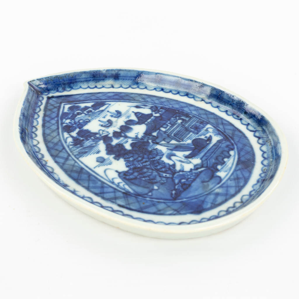 A Chinese dish made of porcelain with a blue-white landscape decor. 