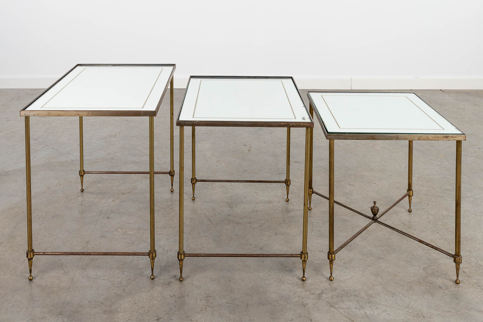 Een collectie van 3 cigogne bijzettafels gemaakt uit glas en messing in de stijl van Maison Jansen. (H:45cm)