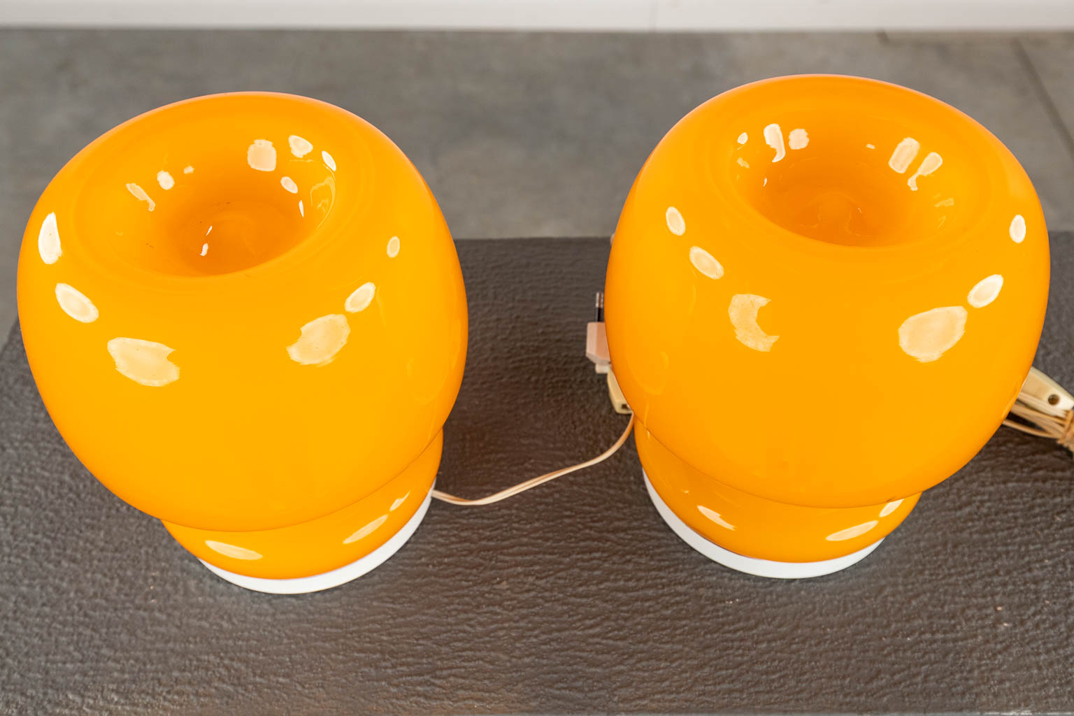 Two mid-century nightlamps and a ceiling lamp, orange glass on metal, circa 1970. (H:65 x D:30 cm)