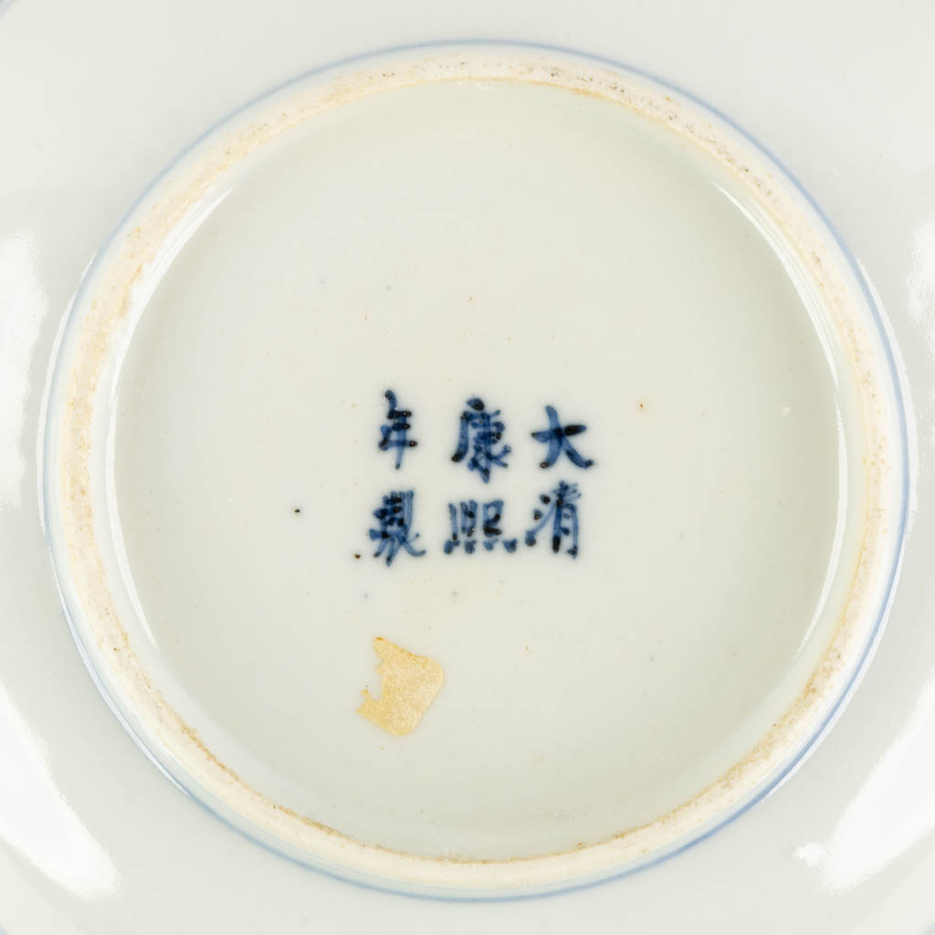 Een Chinees sierbord, blauw-wit met decor van Fauna en Flora, Kangxi merk. (H:3 x D:13,5 cm)