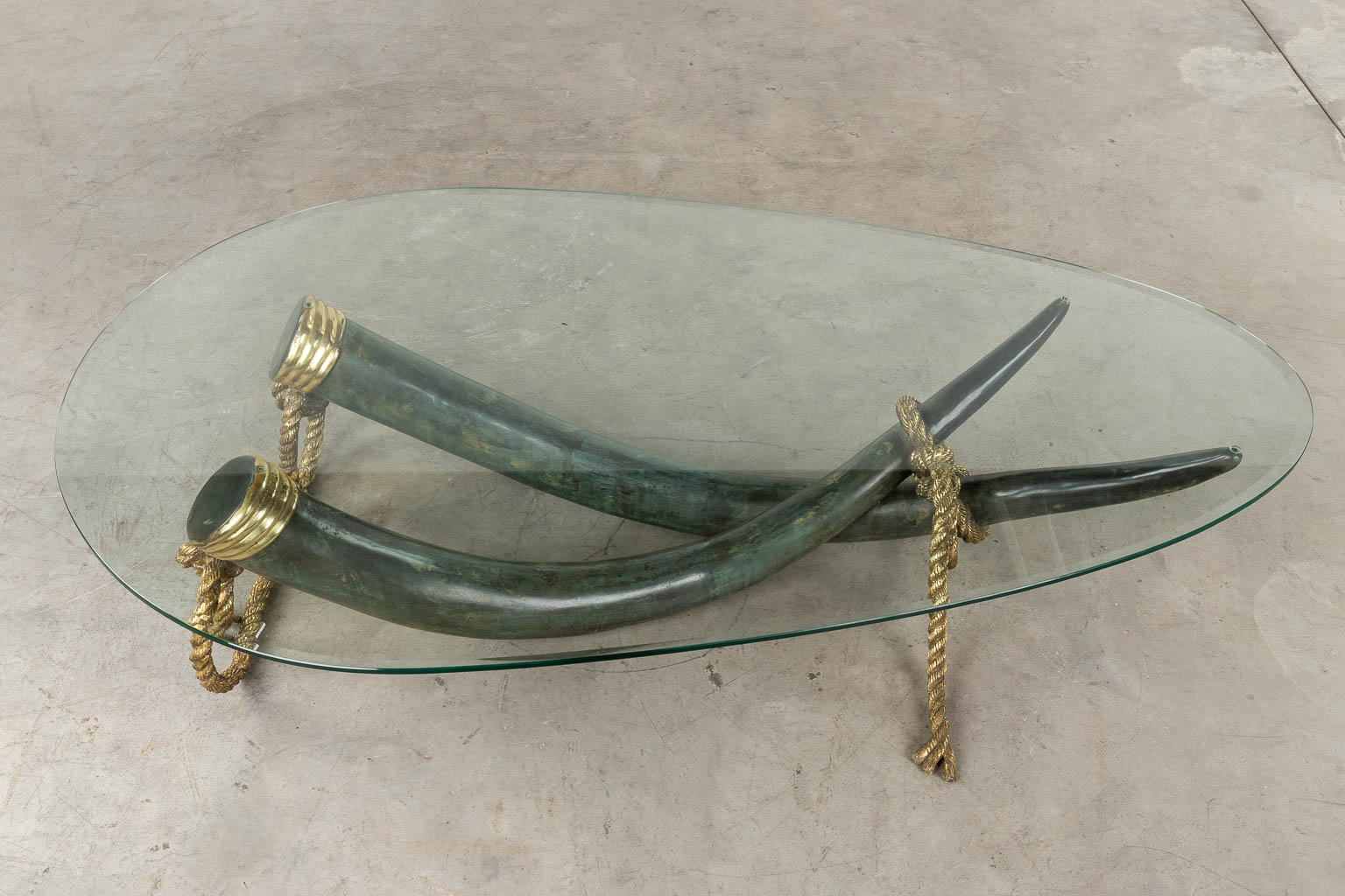 A coffee table, faux tusks, bronze, Valenti, Spain. Circa 1980. (D:100 x W:168 x H:40 cm)