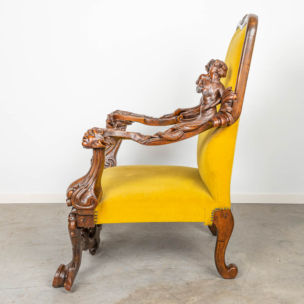 An armchair with richly decorated armrests in the style of Andrea Brustolon