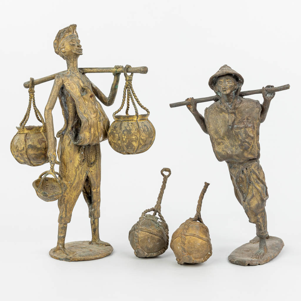 Een collectie van twee bronzen beelden van Oosterse figuren met manden. (H:36cm)
