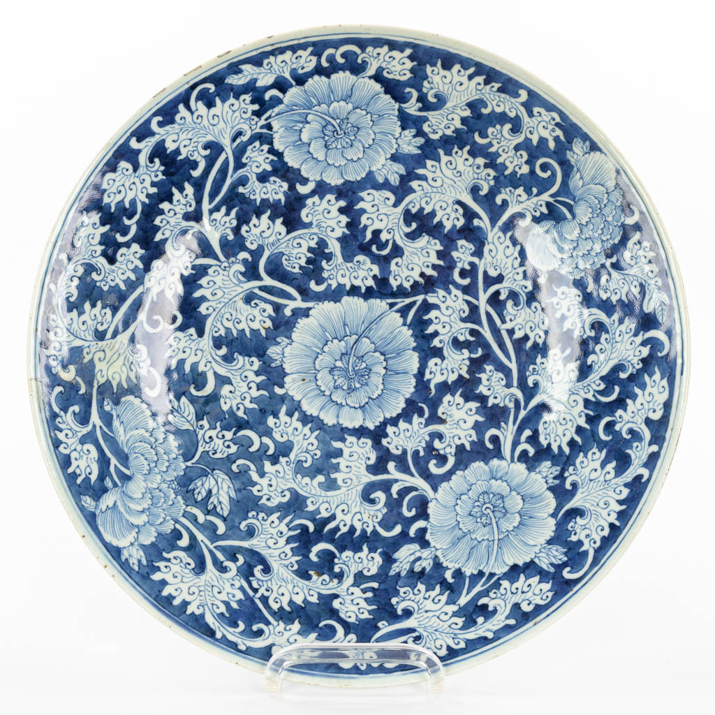Een grote Chinese schaal gemaakt uit porselein met blauw-wit bloemendecor. 