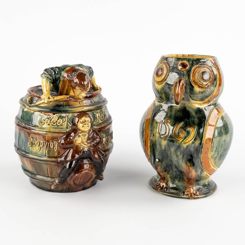 A Tobacco jar 'Vandevoorde', and a pitcher 'Den Uil' in the shape of an owl.. Brugge, Circa 1900. (W:16 x H:20 x D:13,3 cm)