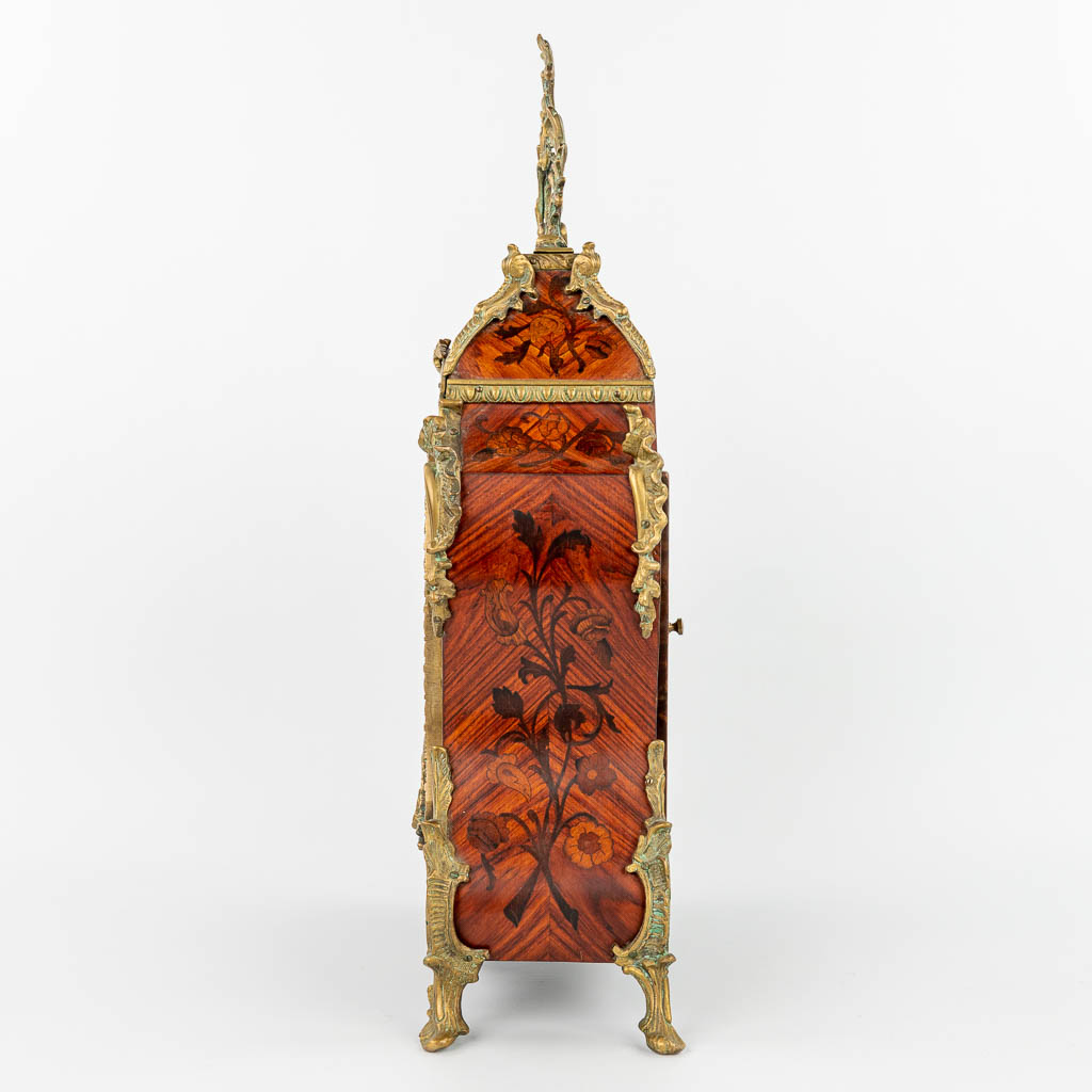 A Kartell clock mounted with bronze and finished with marquetry inlay. (H:79cm)