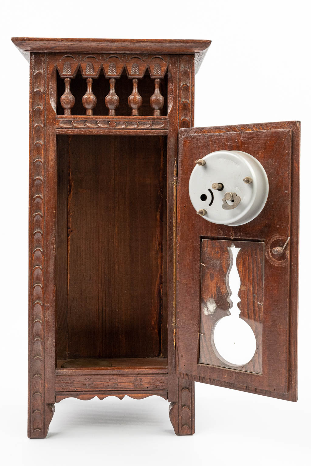 A table clock mounted in a miniature Breton cabinet. (H:35,5cm)