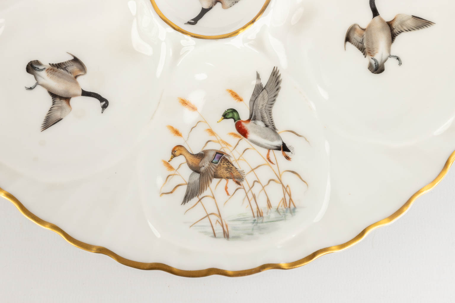 Porcelaine De Paris, France, een collectie van 12 oesterborden met decor van vogels. 20ste eeuw. (D: 23 cm)