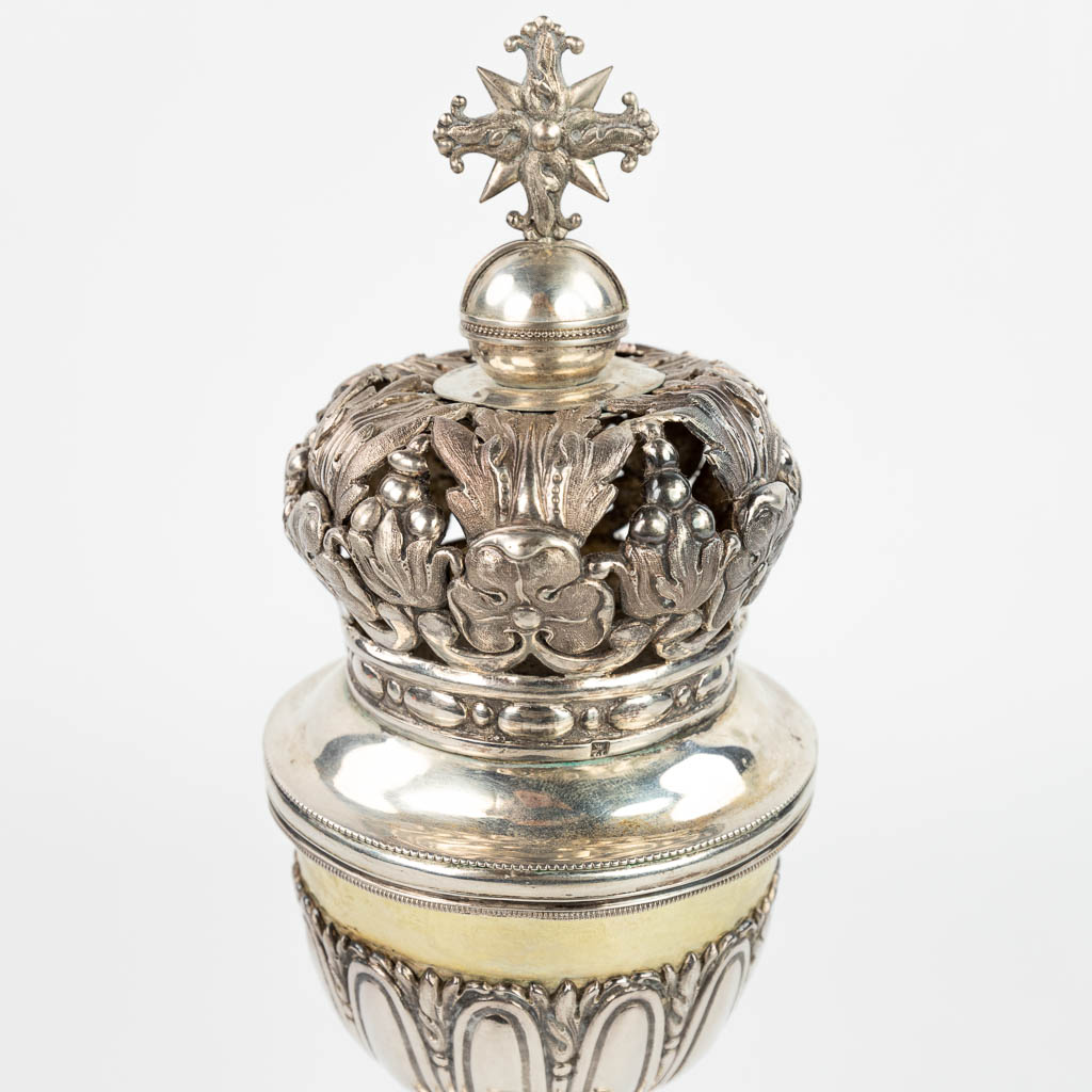Een ciborie gemaakt uit zilver met opengewerkte kroon. Gemerkt met Dubbele Janus, Tweede gehalte 833/1000. 508g. (H:32cm)