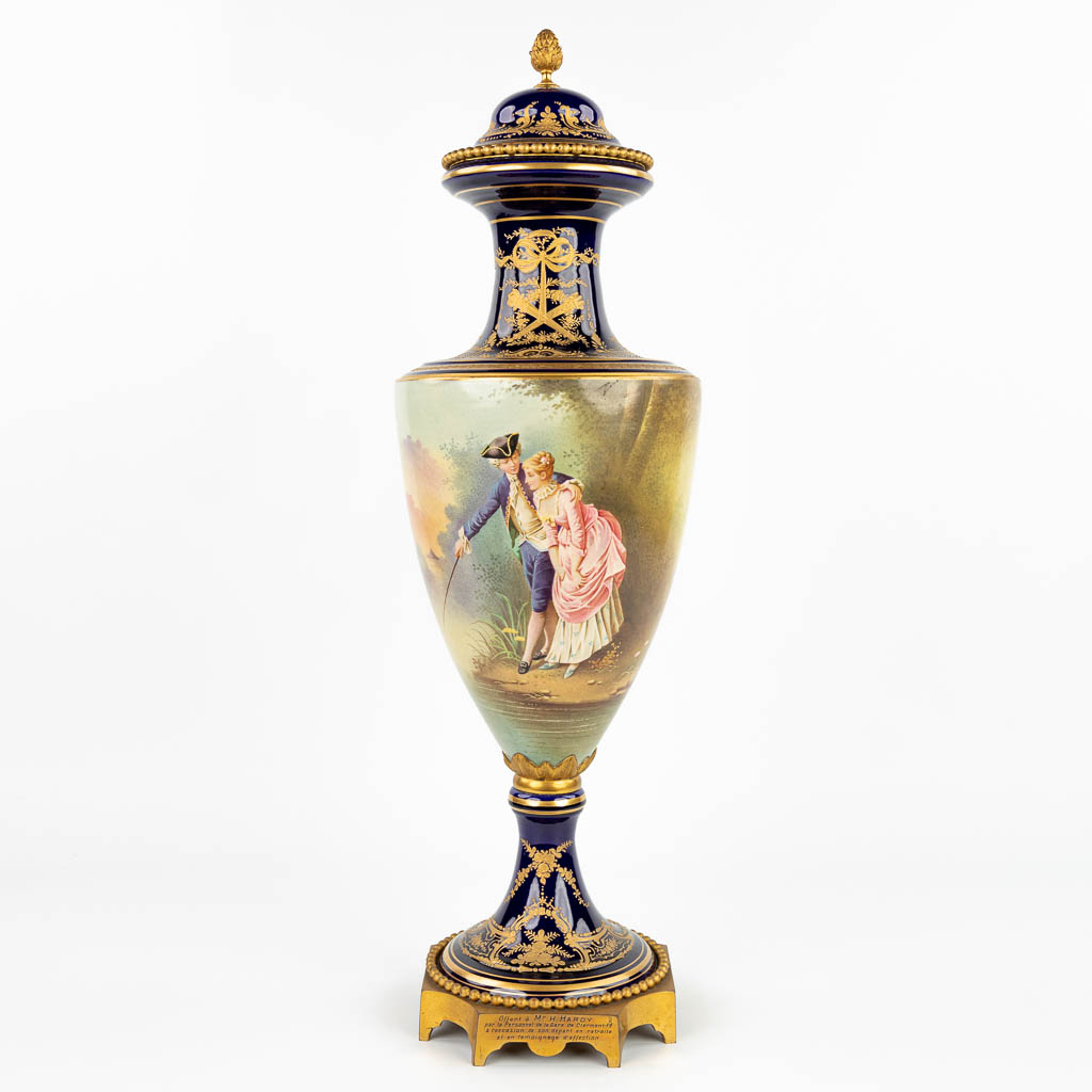 Een vaas met handgeschilderd romantisch decor, gemaakt door Sèvres, gesigneerd E. Grisard. (H:71cm)