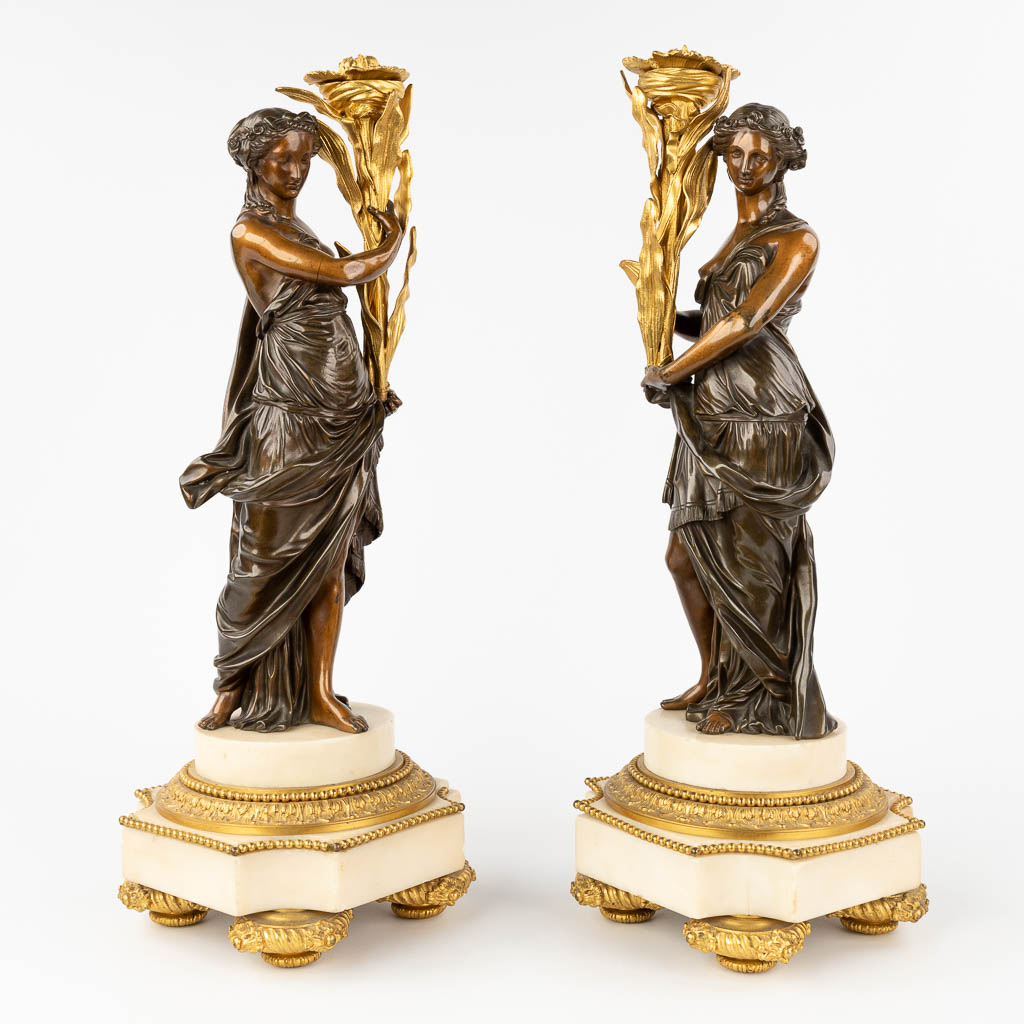  Een paar neoklassieke figuren, verguld en gepatineerd brons op Carrara marmer. 19de eeuw. 