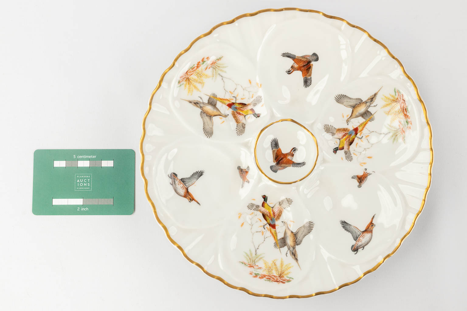 Porcelaine De Paris, France, a collection of 12 oyster plates decorated with birds. 20th C. (D: 23 cm)
