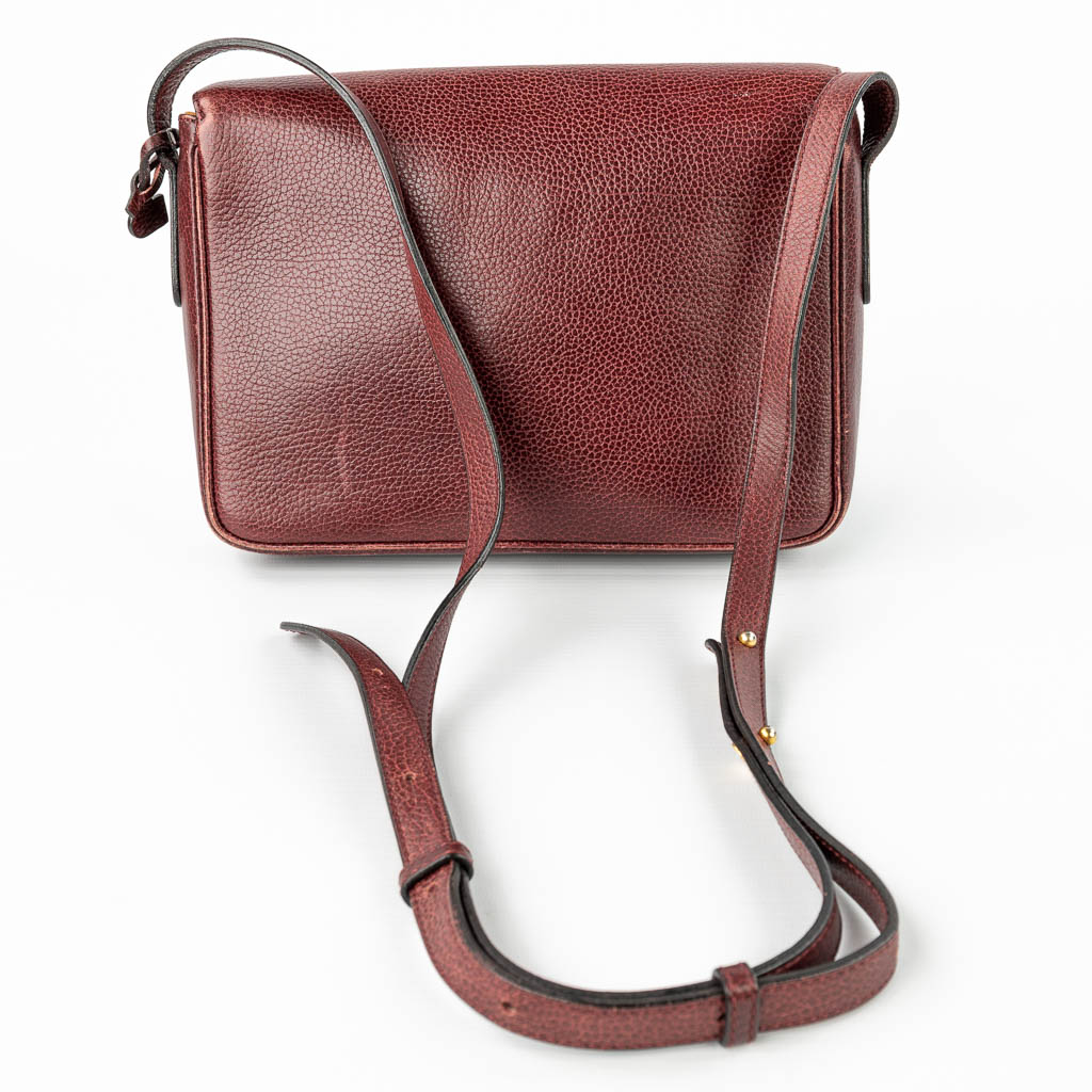 A purse made of red leather and marked Delvaux. (H:18cm)