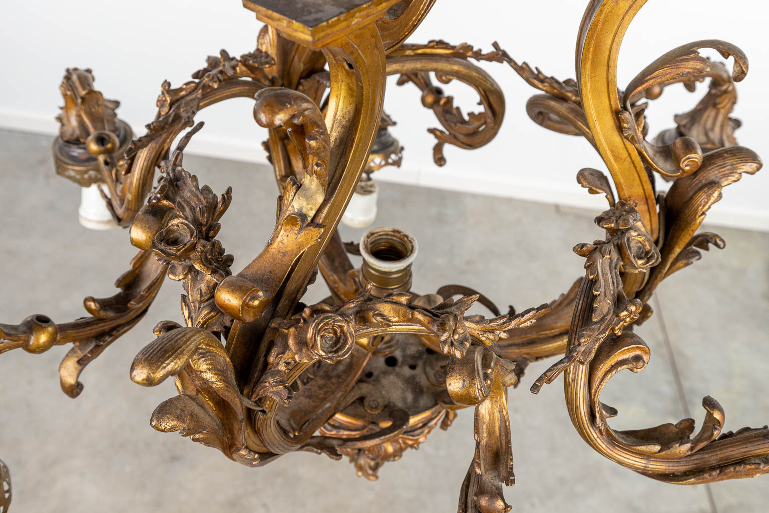 Een grote luchter gemaakt uit brons in Lodewijk XV stijl, en afgewerkt met glazen lampkappen. (H:103cm)