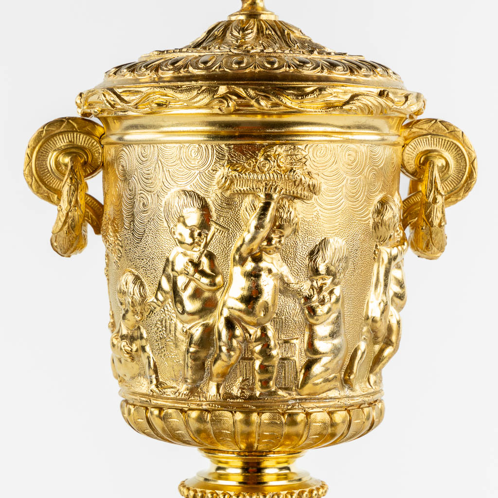 A gilt bronze mantle clock, richly decorated with putti, ram