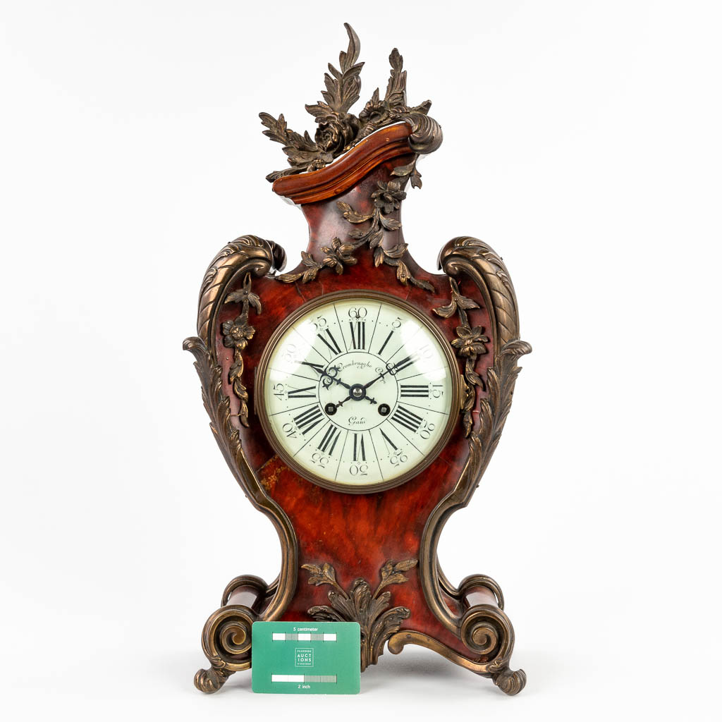 A mantle clock, tortoiseshell finished with gilt bronze in Louis XV style. 19th C. (D:14 x W:28 x H:53 cm)