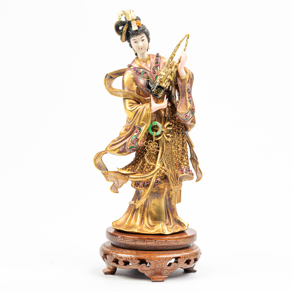  A statue of a musical figurine with a Sheng music instrument. The statue is marked 18k and made of 18kt gold.