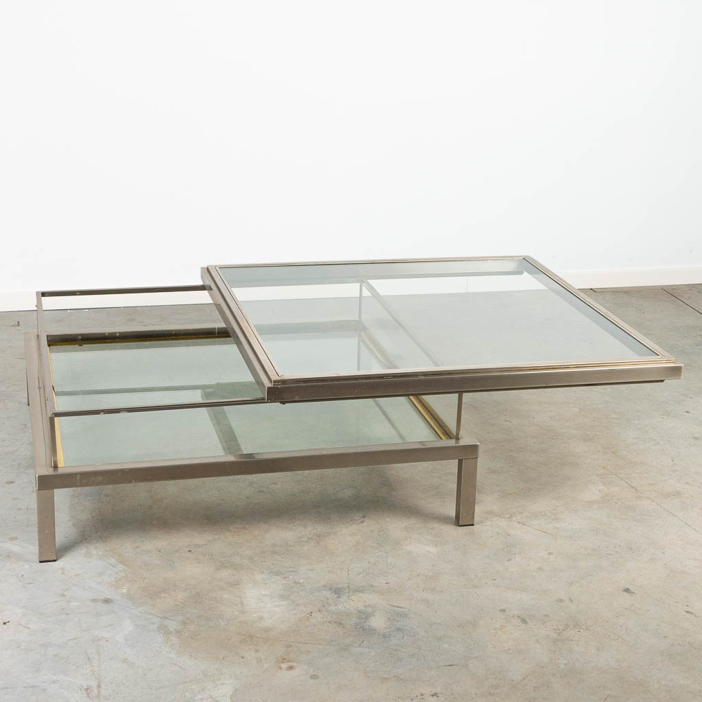 A mid-century coffee table 'slide' made by Maison Jansen. Made of gold plated metal and glass