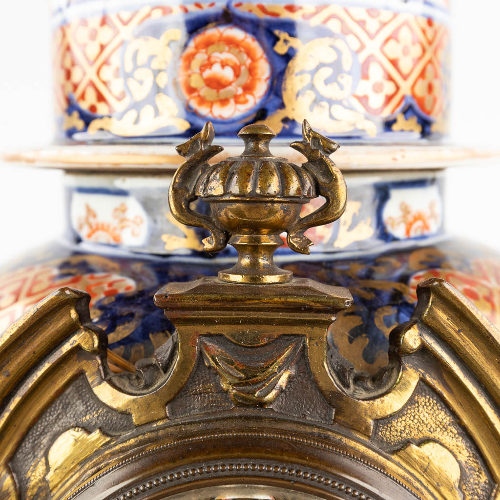 A mantle clock, Japanese Imari porcelain mounted with bronze and finished with lion