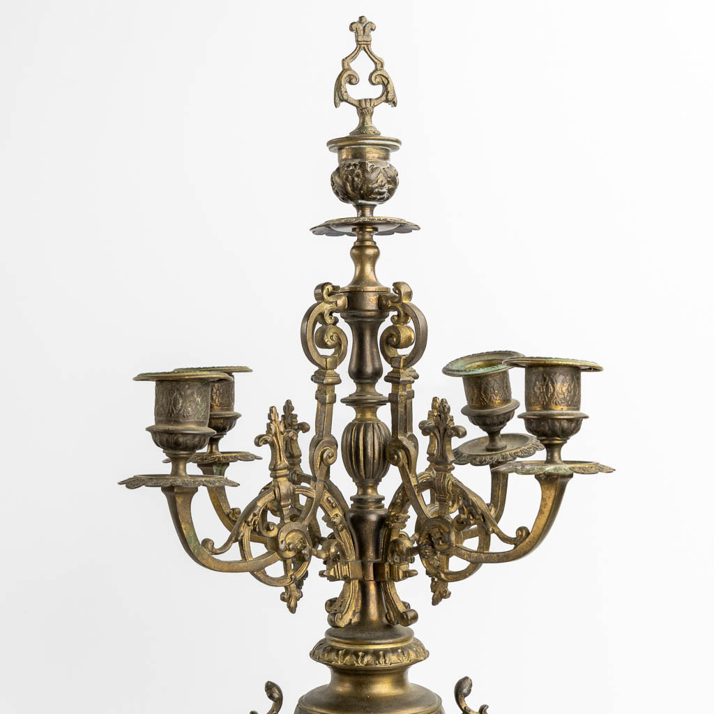A three-piece mantle garniture in the shape of a castle with a knight, patinated bronze. Circa 1900. (L:18 x W:33 x H:57 cm)