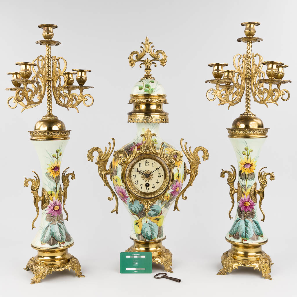 A three-piece mantle garniture clock and candelabra, circa 1900. (W: 34 x H: 63 cm)