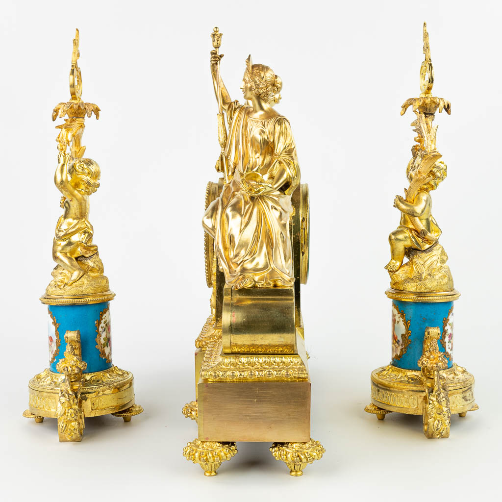 A three-piece garniture clock with candelabra, made of gilt bronze and decorated with sèvres plaques. Marked Balthazard. (H:40,