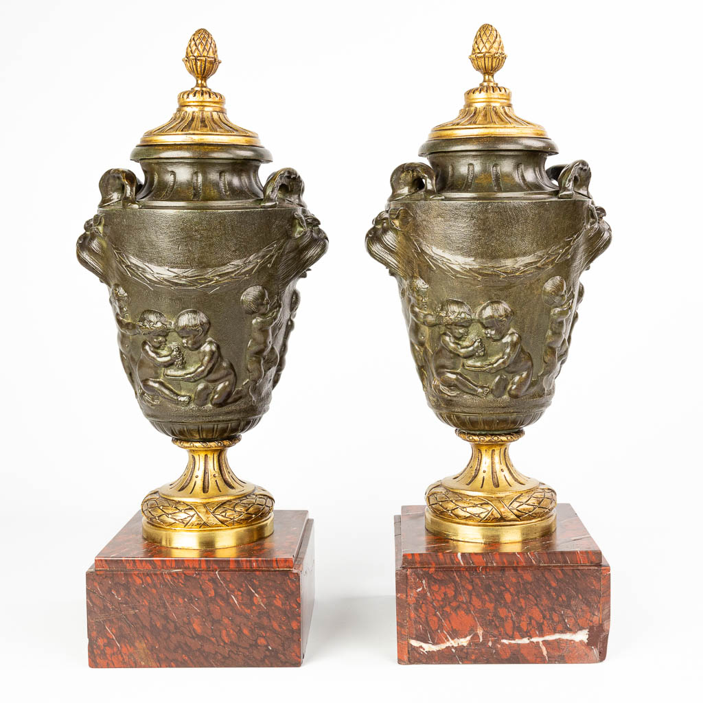 Een paar cassolettes gemaakt uit gepatineerd en verguld brons en versierd met putti