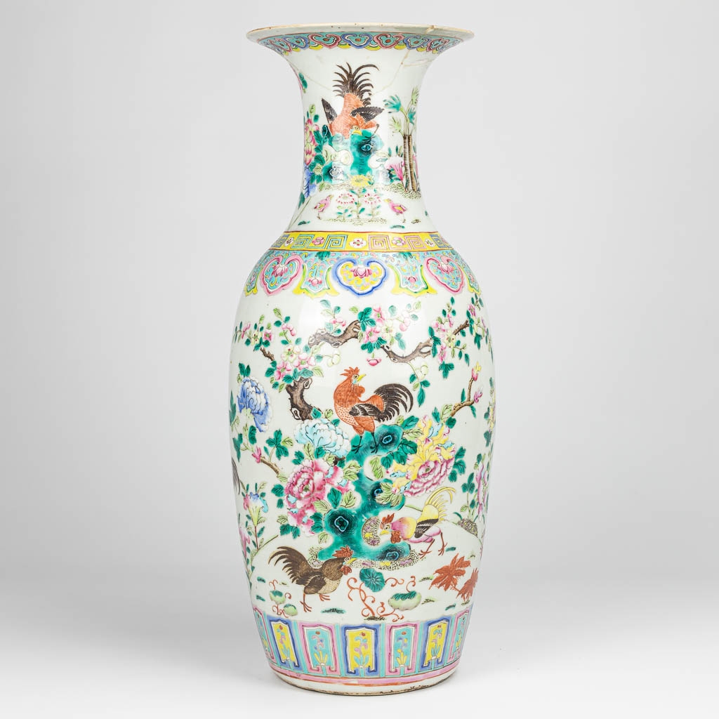 Een grote vaas gemaakt uit Chinees porselein en versierd met hanen en bloemen.