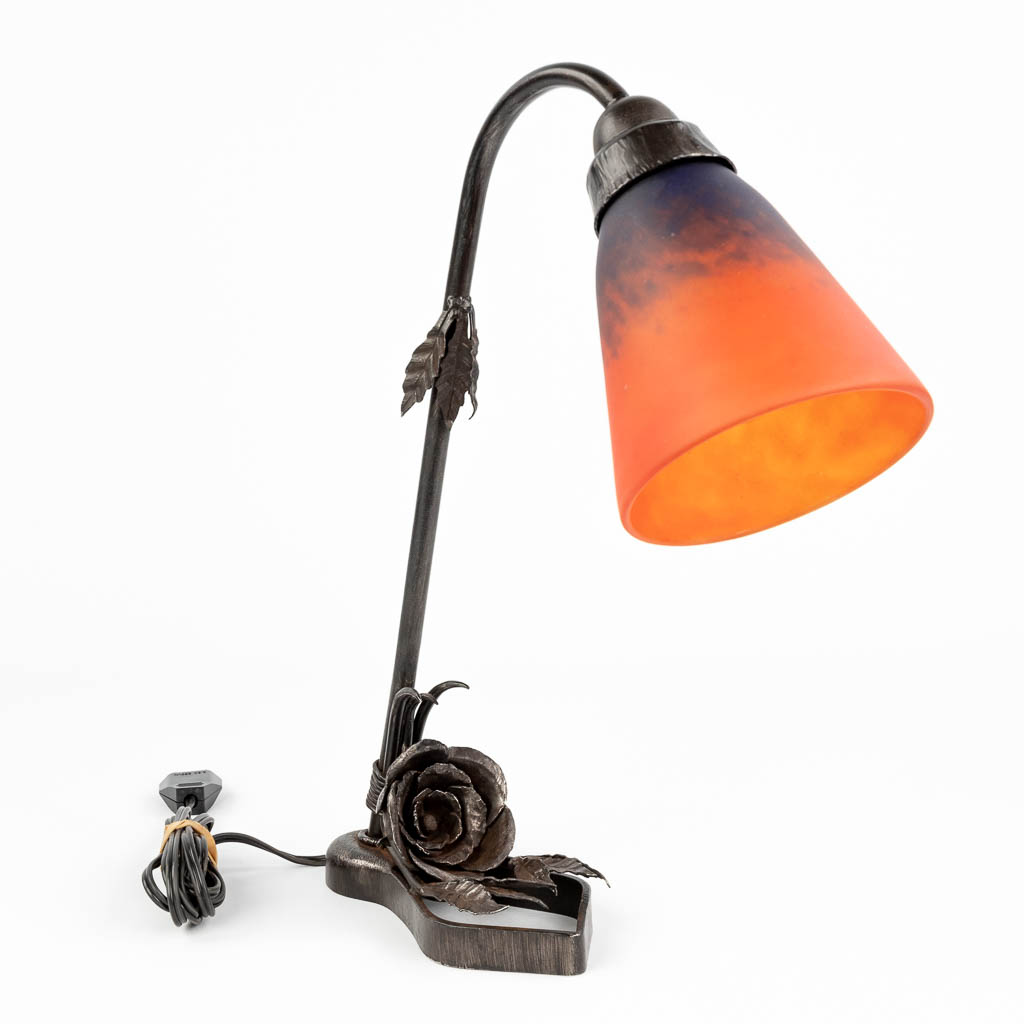 A wrought-iron table lamp in art deco style, with a lampshade by Schneider. (H:40 cm)