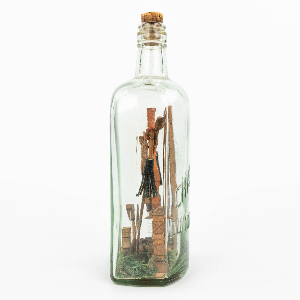 A Corpus Christi and crucifix mounted in a glass bottle. (H:24cm)