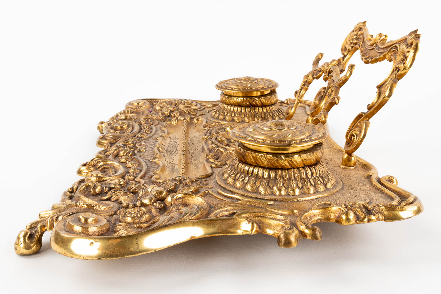 A large inkwell holder and letter opener, brass in rococo style. 20th C. (L: 28 x W: 42 x H: 13,5 cm)