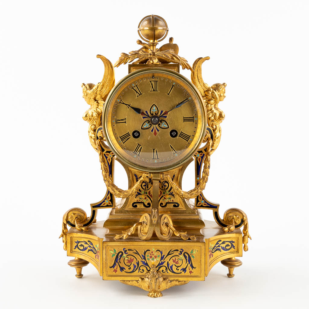 A small mantle clock, bronze decorated with enamel, angels and a globe. 19th C. (D:12,5 x W:20 x H:28 cm)